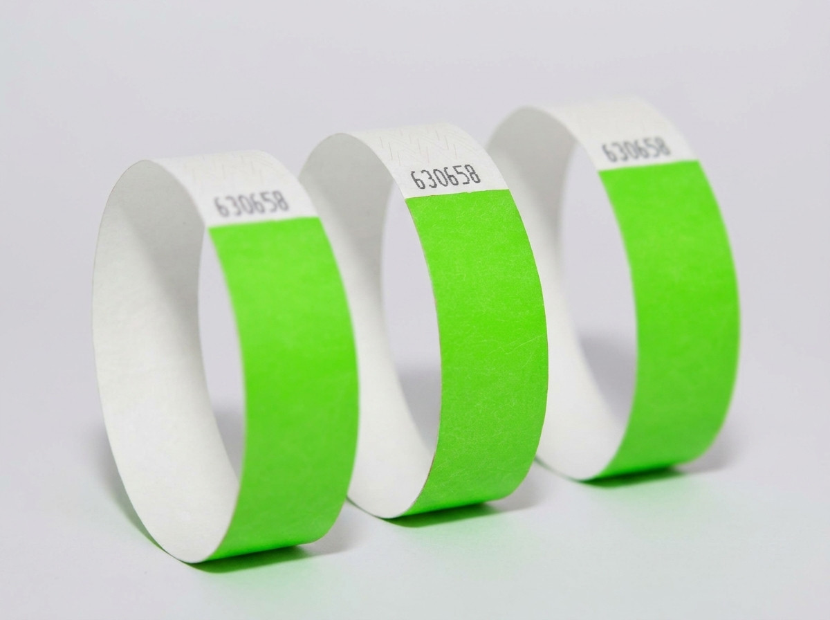 Comparatif côte à côte d'un bracelet Tyvek coloré et d'un bracelet identification blanc élégant sur un fond en bois clair